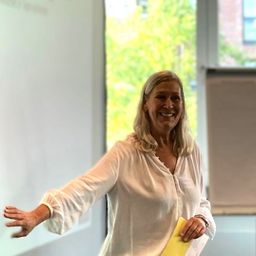 Susanne Maisch steht vor einer Gruppe von Menschen und schaut auf ein Flipchart.